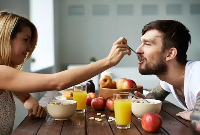 uma mulher alimenta um homem com nozes para aumentar a potência